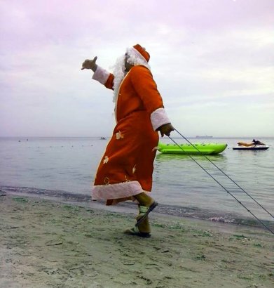 На жарком одесском пляже — Дед Мороз с санками и мешком подарков