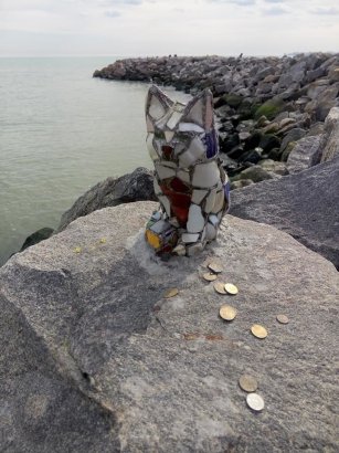 Стеклянной кошке на одесском пляже начали приносить деньги